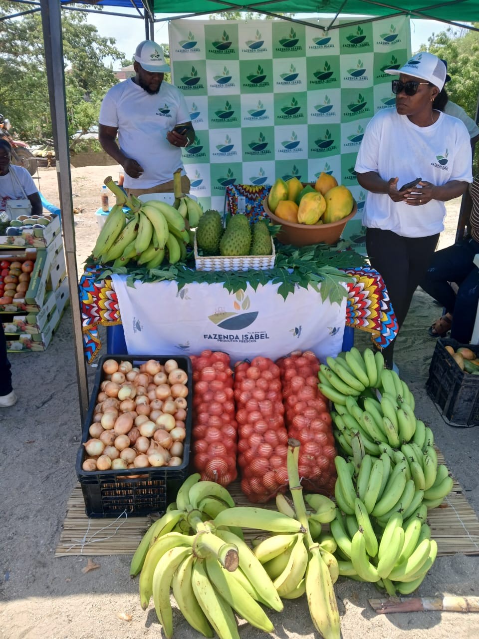 Equipa da Fazenda Isabel junto ao expositor de frutas e produtos agrícolas